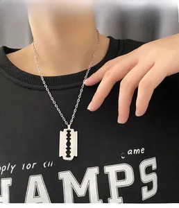 Primo piano di una collana con ciondolo a lama di rasoio in acciaio al titanio argento