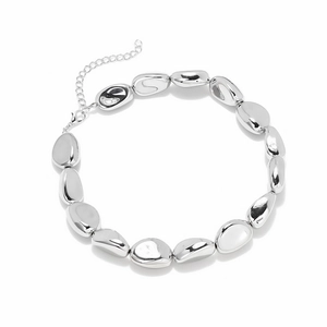Macro detail of silver irregular metallic beads necklace with lobster clasp and chain
