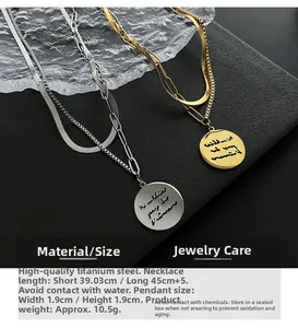 Detail of layered titanium steel necklace with engraved coin pendant and paperclip chain