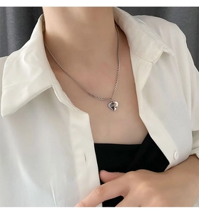 Nahaufnahme eines silbernen Herzanhängers mit Lover-Gravur an einer feinen Edelstahlkette