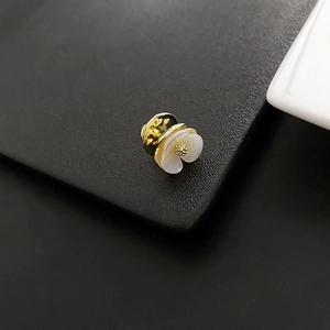 Exquisite shell flower brooch with gold metal center shown from a 45-degree angle view