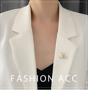 Detail of three butterflies brooch with shell wings and zircon inlay on a white blazer