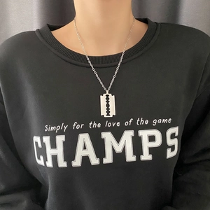 Collana con ciondolo a lama di rasoio in acciaio al titanio lucido su felpa con cappuccio