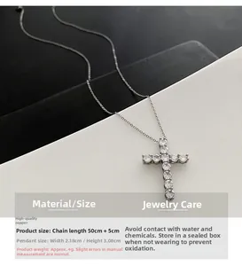 Detailed view of silver cross pendant with inlaid zircons and dimensions on dark background