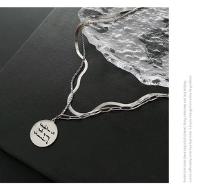 Detailed view of silver double-layer necklace with snake chain and round coin pendant