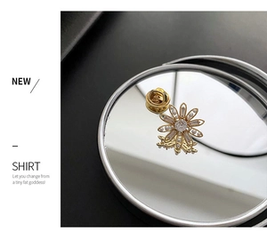 Détail d'une élégante broche fleur avec pétales en perles blanches et base dorée