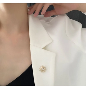 Détail d'une broche fleurie avec cristaux et perles sur le revers d'un costume
