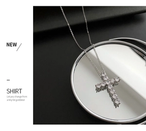Detail shot of a silver cross pendant necklace featuring brilliant round-cut cubic zirconia
