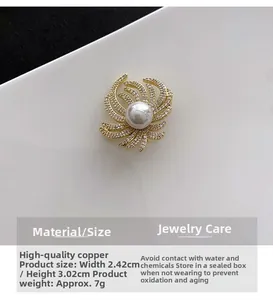 Detail of gold sunburst brooch with micro-pave zircons and center pearl 3x2.4cm