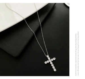 Macro detail of a silver cross pendant necklace inlaid with eleven sparkling zircons