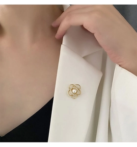Gros plan sur la broche fleur de camélia en perles sur un revers de veste élégant