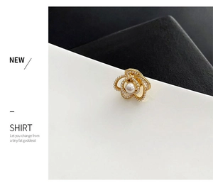 Détail macro de broche camélia dorée avec perles pour tailleurs et chemises chic