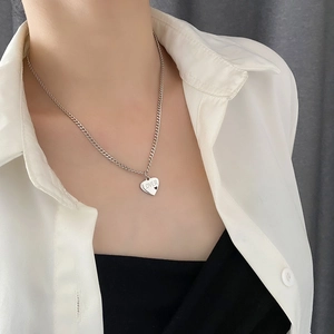 Minimalistische silberne Titanstahl-Herzkette mit LOVER-Gravur am Modell getragen