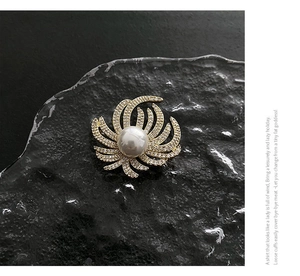 Macro detail of luxury copper brooch featuring a large pearl and zircon-set petals