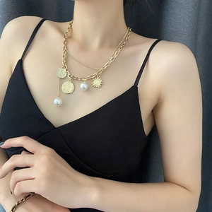 Retro hip-hop gold layered necklace with coin, pearl, and sun pendants on model