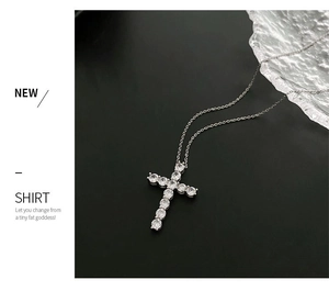 Close-up of silver cross pendant with sparkling zircons on a minimalist chain