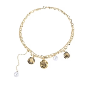 Vintage gold layered necklace with pearl charms, moon pendant, and sun coin medallion