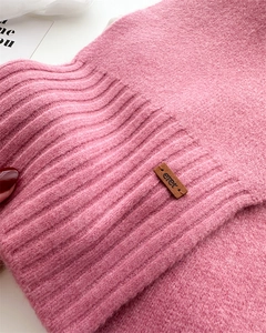 Details des rosa gerippten Strickschals mit braunem Eret-Logoetikett aus Leder