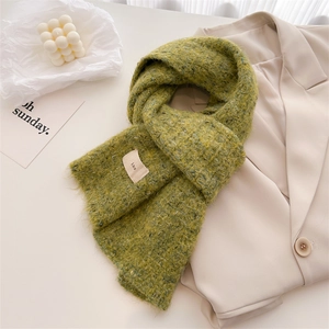 Detailed texture of olive green wool knit scarf with ins woven label and warm fuzzy surface
