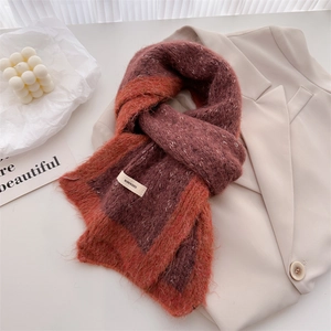 Detail of color-block knit scarf with brand tag on soft mohair wool texture