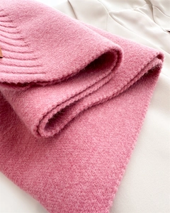 Detailansicht eines rosa Strickschals mit weicher Mohair-Textur und Rippstrickkante