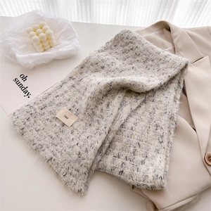 Detail of wool-blend knit scarf with ins label, stylish gray knit with black flecks