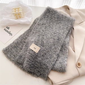 Detailed view of grey wool knit scarf texture with ins fabric label on a blazer