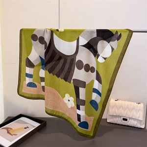 Detail view of abstract horse print scarf with herringbone weave and rolled hem edge
