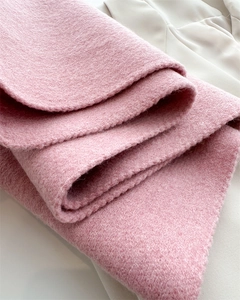 Nahaufnahme der rosa Wolle zeigt die dicke Strickstruktur und das warme Material