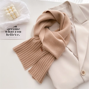 Nahaufnahme eines weichen Strickschals aus Wolle mit Rippmuster und ener Markenlabel