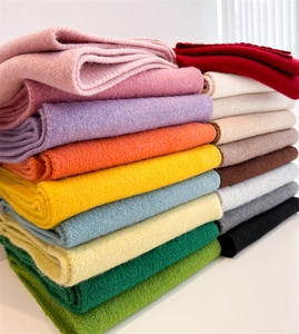 Nahaufnahme bunter dicker Strickschals aus Wolle in weichen Pastell- und Neutraltönen