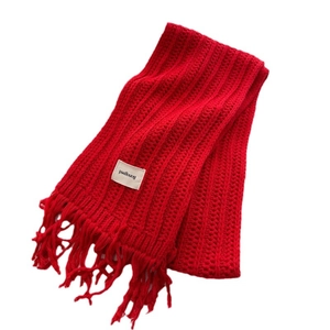 Red wool knit scarf with stylish cable pattern and long tassels for winter warmth