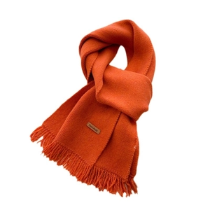 Retro orange knitted scarf with fringe and 'Hand Made' leather tag on white background