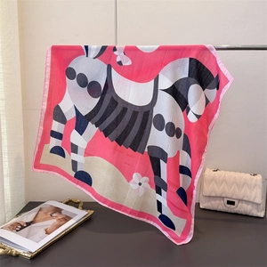 Detail of pink silk square scarf with zebra and butterfly print on a metal rack