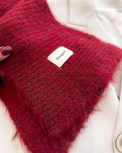 Gros plan sur l'écharpe en maille mohair rouge foncé avec étiquette de logo sur manteau