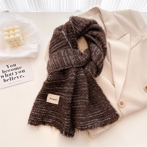 Détail d'une écharpe en maille marron café avec texture laine et étiquette vintage