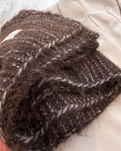 Gros plan sur une écharpe en mohair marron foncé avec motif quadrillé gris et étiquette