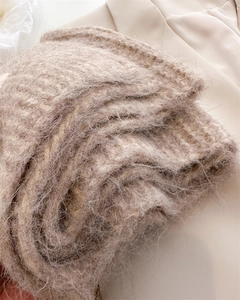Gros plan d'une écharpe en maille épaisse et moelleuse au fini mohair doux beige clair