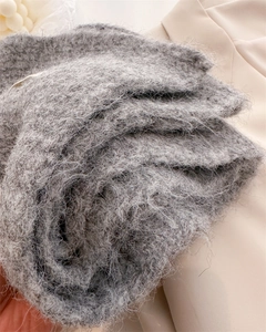Gros plan sur la texture d'une écharpe en maille grise avec fibres de mohair et tissage doux