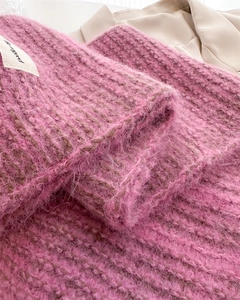 Gros plan d'une écharpe en maille mohair rose avec texture laineuse et étiquette en tissu