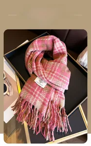 Detail of pink plaid scarf with fringe tassels on a luxury tray with accessories