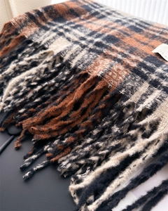 Close-up of caramel plaid scarf showing soft fringe details and thick wool-like texture