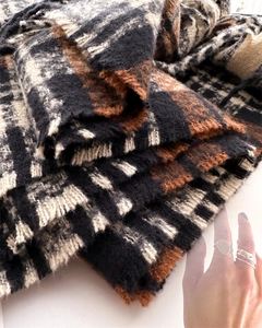 Close-up of thick checkered knit scarf in houndstooth pattern with soft fringe detail