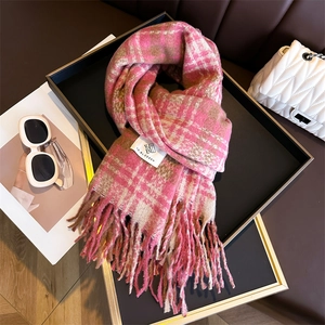 Close-up of pink and brown plaid cashmere scarf with long tassels and brand label
