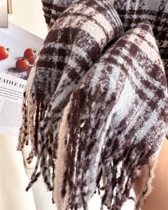 Close-up of thick plaid scarf texture with long fringe and fuzzy brushed wool material