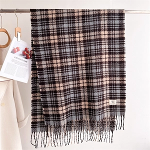 Detailed view of Scottish plaid scarf featuring long tassels and soft warm fabric texture