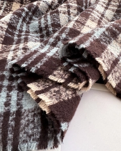 Close-up of thick plaid cashmere-like fabric with soft fringe and fuzzy texture detail