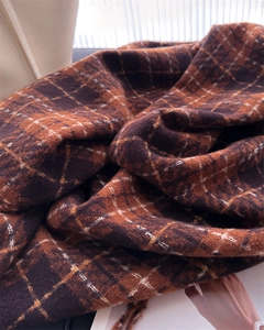 Close-up of thick plaid scarf texture showing soft brown and orange brushed fiber detail
