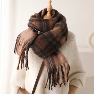 Macro detail of the brown plaid scarf showing thick cashmere texture and fringe tassels