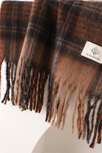 Close-up of brown plaid scarf texture showing thick knit fiber and tassel details